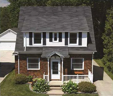 House with its older asphalt-shingle roof before replacement — Owens Corning reference photography